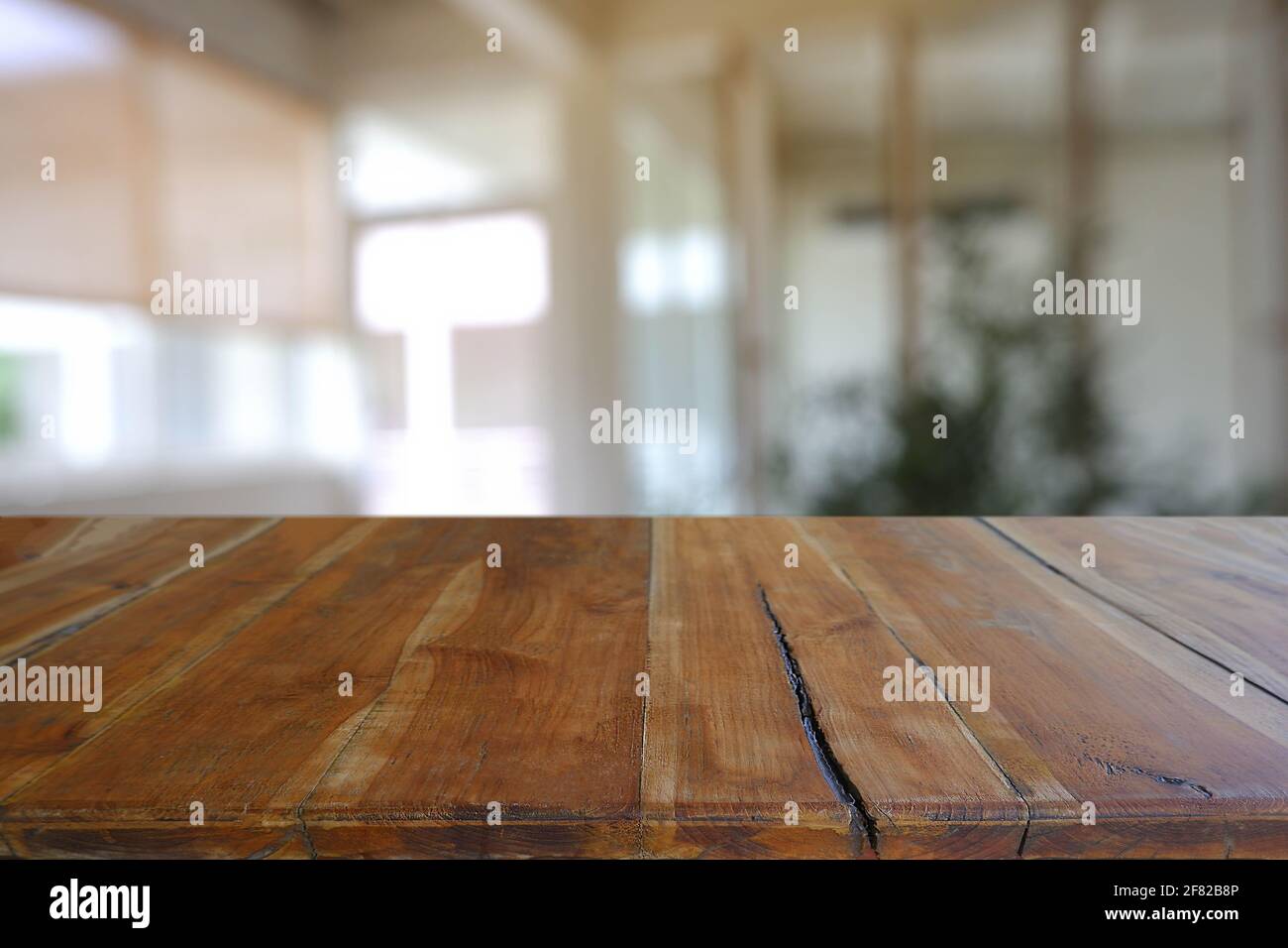 Leerer Holztisch vor dem abstrakten Blurred Cafe, Restaurant in der Nacht. Für die Montage der Produktanzeige oder für das Design eines visuellen Layouts - Bild Stockfoto