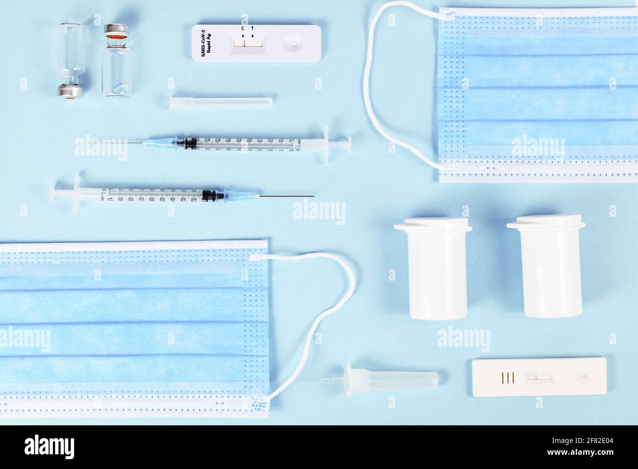Schneller Antigentest, medizinische Gesichtsmasken, Impfstofffläschchen mit Spritze und Medikamentenflaschen. Tools zur Bekämpfung der Corona-Virus-Pandemie Stockfoto