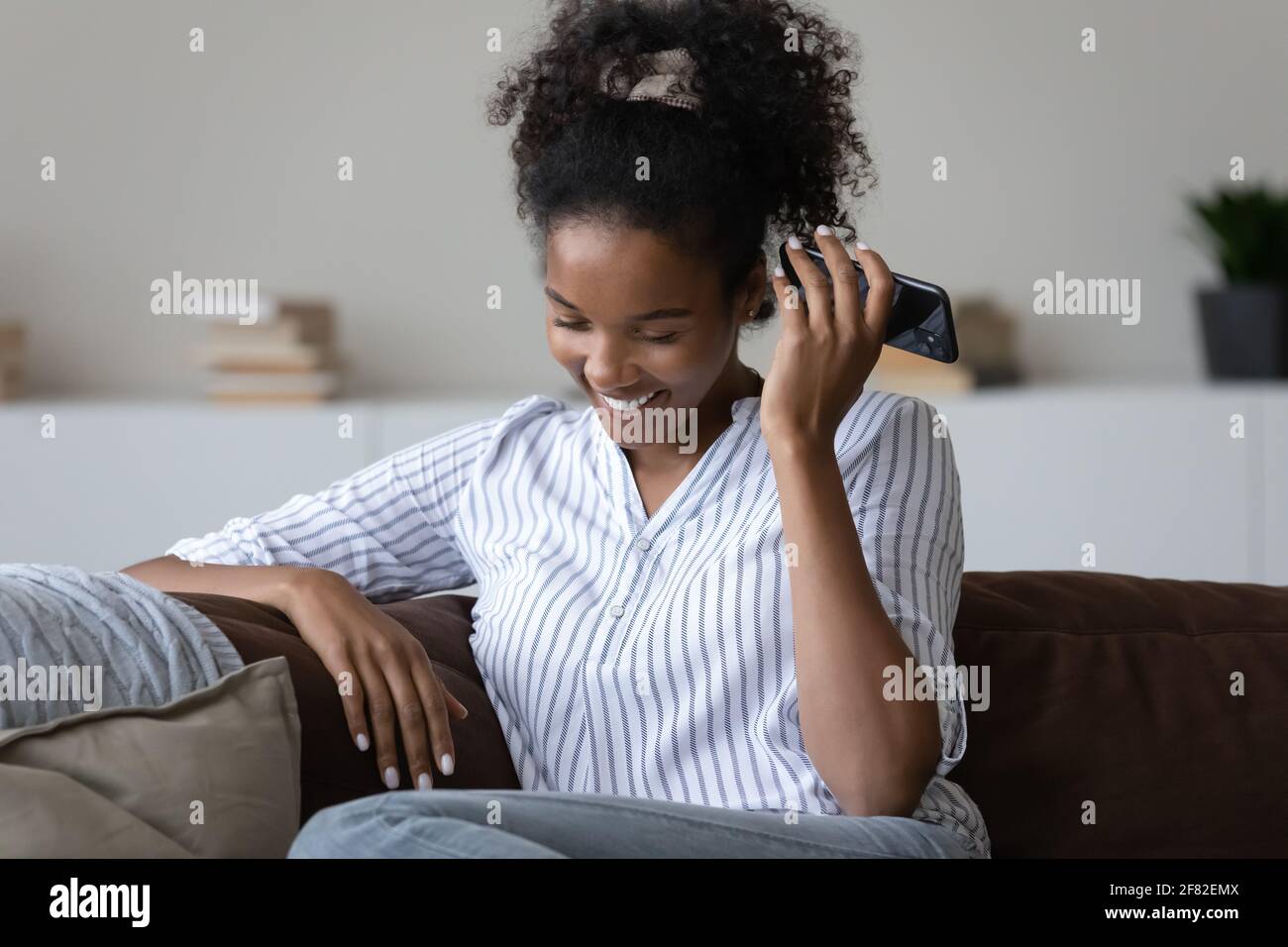 Glückliche Biracial Frau verwenden Handy-Chat mit Sprachnachrichten Stockfoto