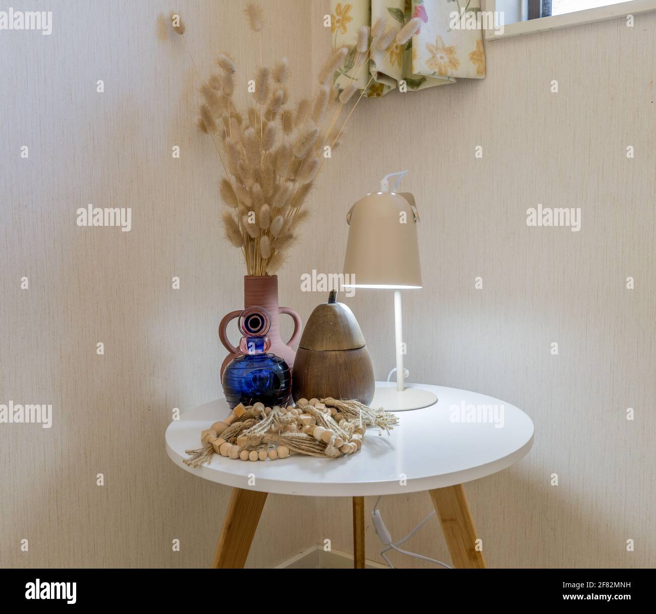 Ein weißer Couchtisch am Fenster mit einer Lampe Und andere Dekore darauf an der Ecke von A Zimmer Stockfoto