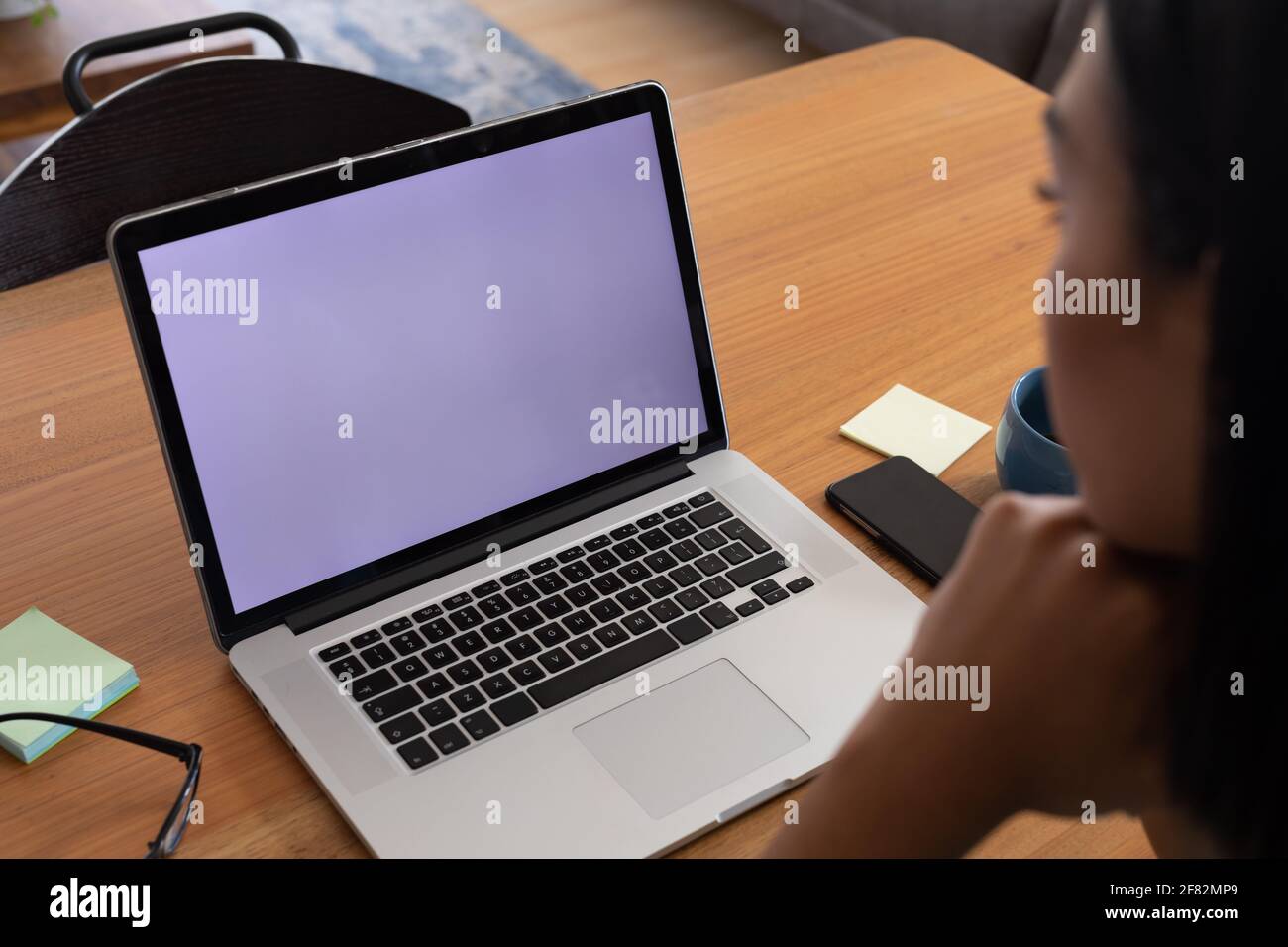 Gemischtes Geschlecht fließender Mann, der zu Hause arbeitet und Videoanruf mit einem Laptop macht, Bildschirm zum Kopieren von Speicherplatz Stockfoto