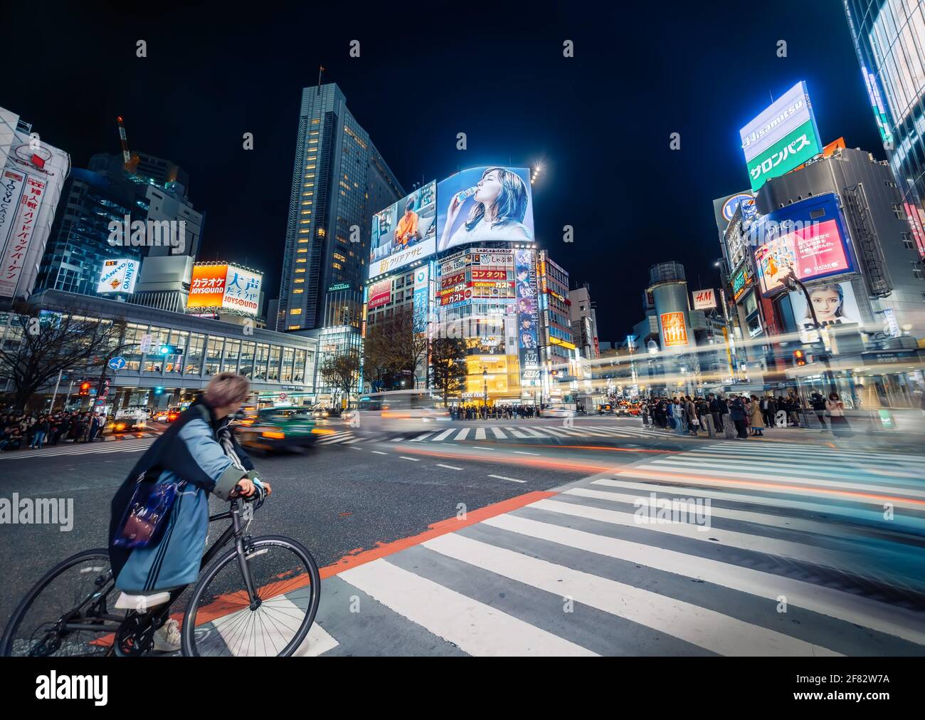 Tokio - 27. März 2019 - elektrisierende Shibuya-Kreuzung bei Nacht mit Neonschildern und Nachtleben und bewegter Verkehr, Tokio, Japan Stockfoto