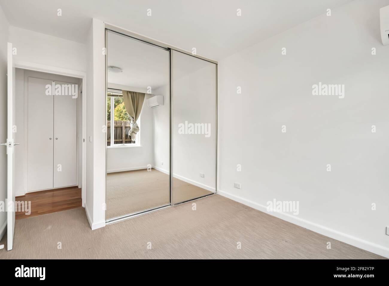 Ein Spiegelschrank in einem leeren weißen Raum Stockfoto