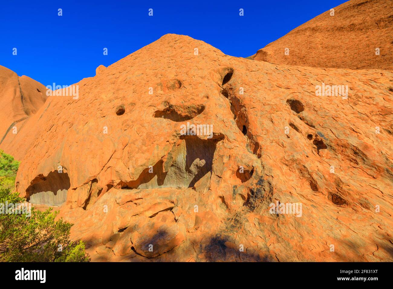 Details von roten Sandsteinfelsen mit Höhlen entlang des Mala Walk am Fuße des Ayers Rock im Uluru-Kata Tjuta National Park, Northern Territory, Australien. Rot Stockfoto