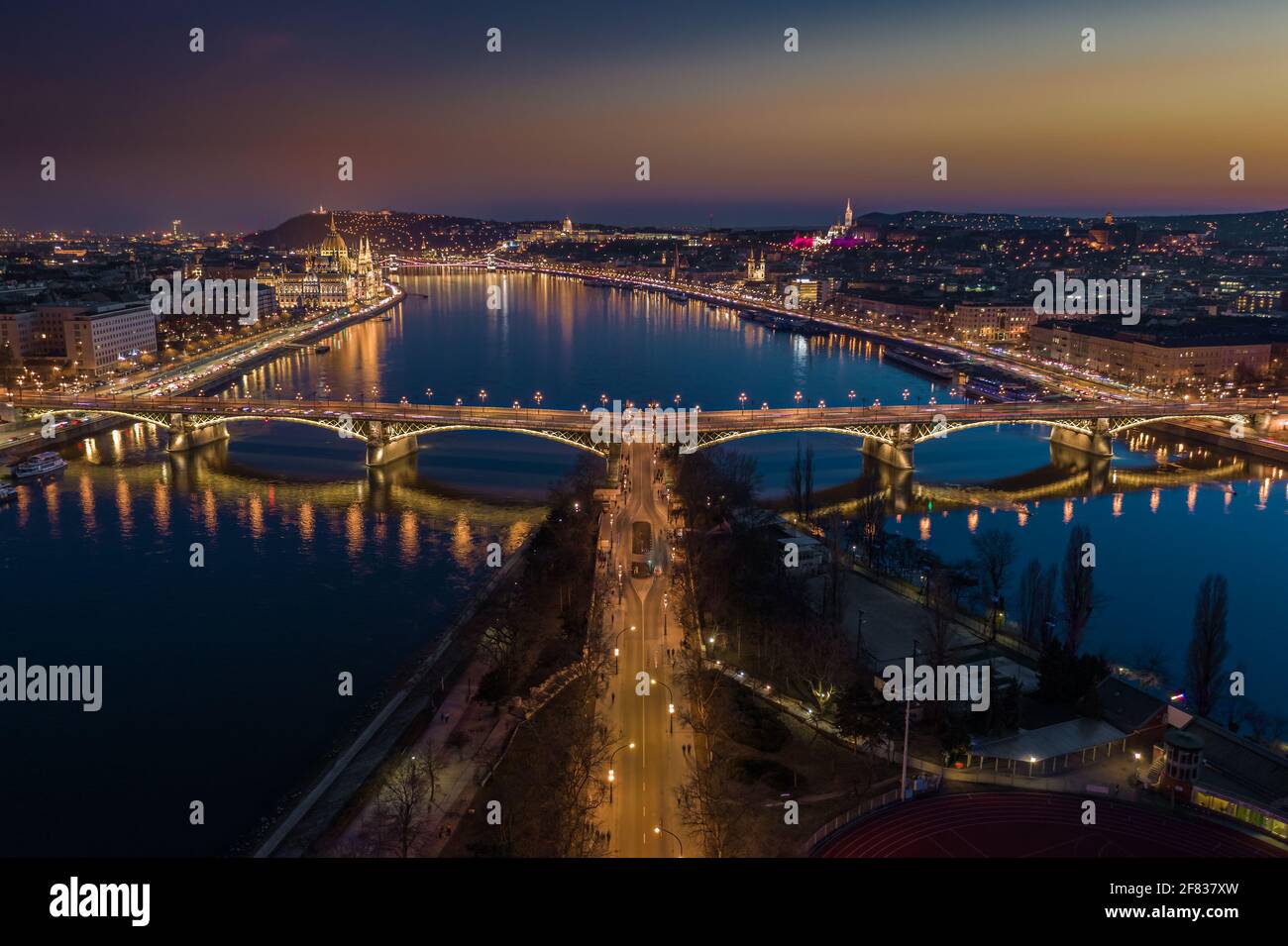 Budapest, Ungarn – Panoramablick auf die Skyline der Luft auf die beleuchtete Margaretenbrücke in der Abenddämmerung. Ungarisches Parlament, Kettenbrücke Szechenyi und Buda Castl Stockfoto