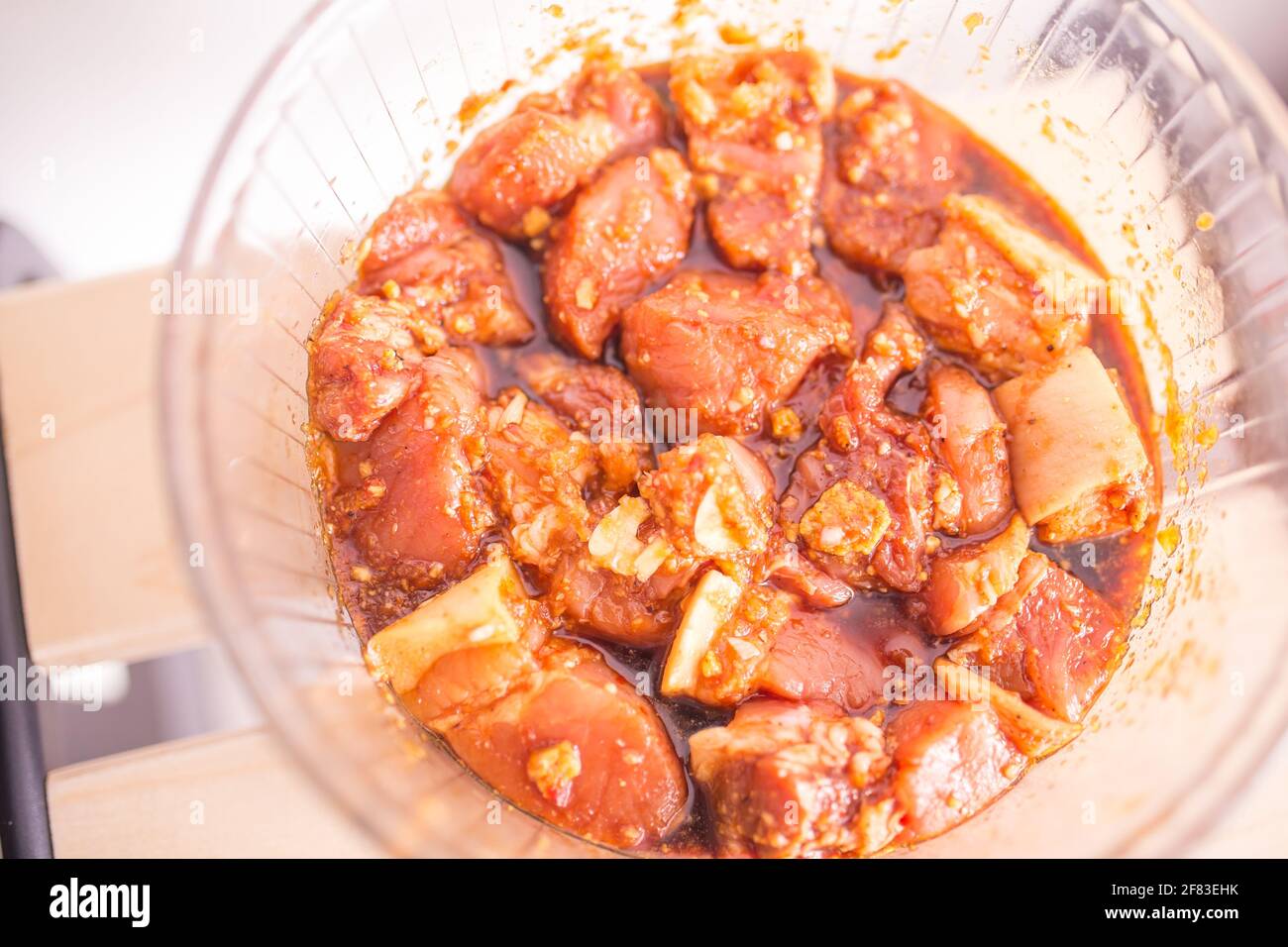 In einer Glasschüssel mariniertes Schweinefleisch mit Karamell und Gewürzen Stockfoto