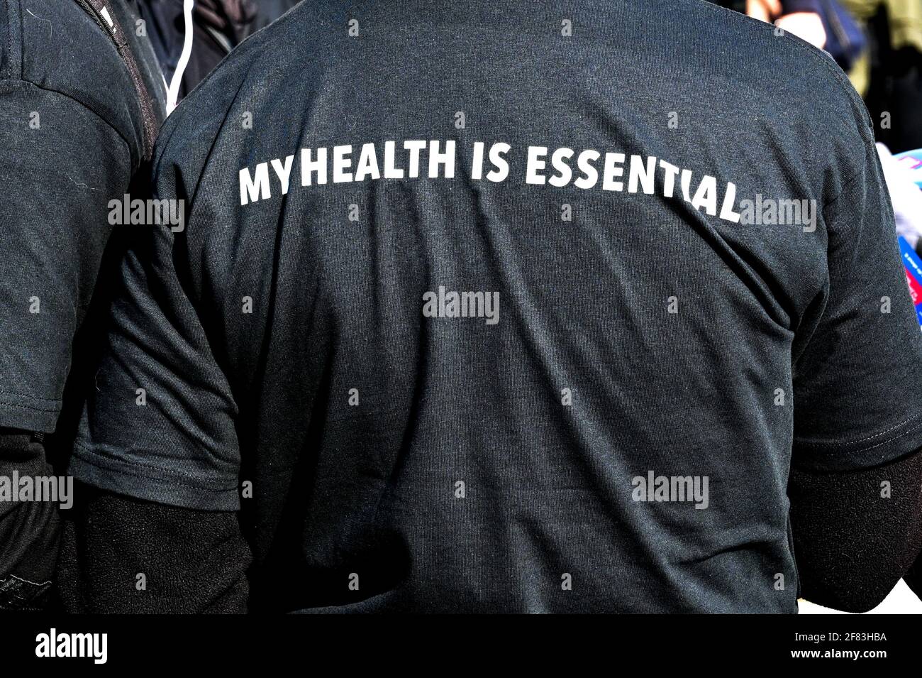 Botschaft über die Bedeutung der Gesundheit auf der Rückseite des T-Shirts einer Person. Stockfoto