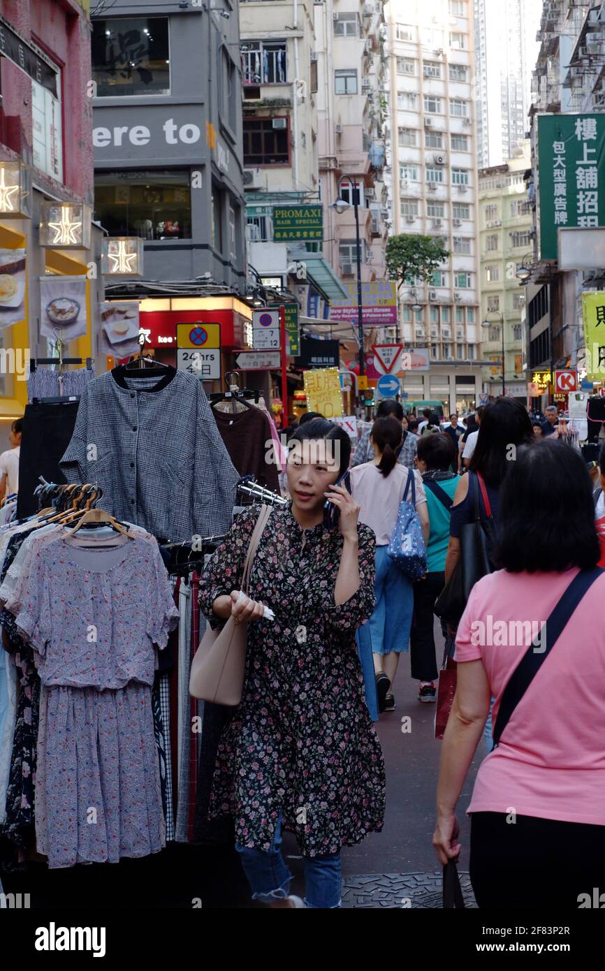 Straßenszene in Hongkong, in der eine Frau durch die Menschenmenge läuft Wan Chai Stockfoto