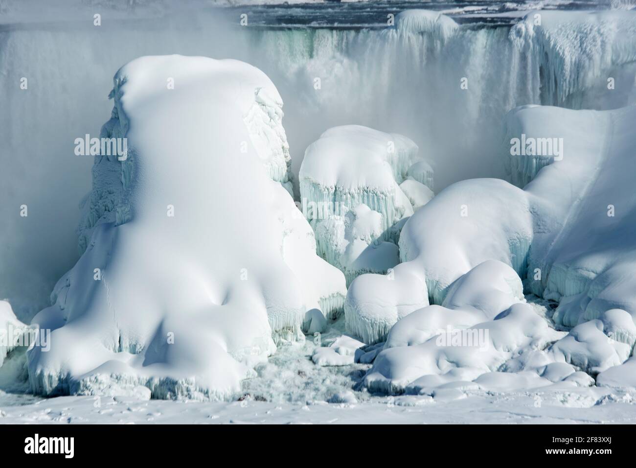 USA, New York, Niagarafälle, die American Falls gefroren über mit großen Eisformationen im Winter an einem hellen sonnigen Tag Stockfoto