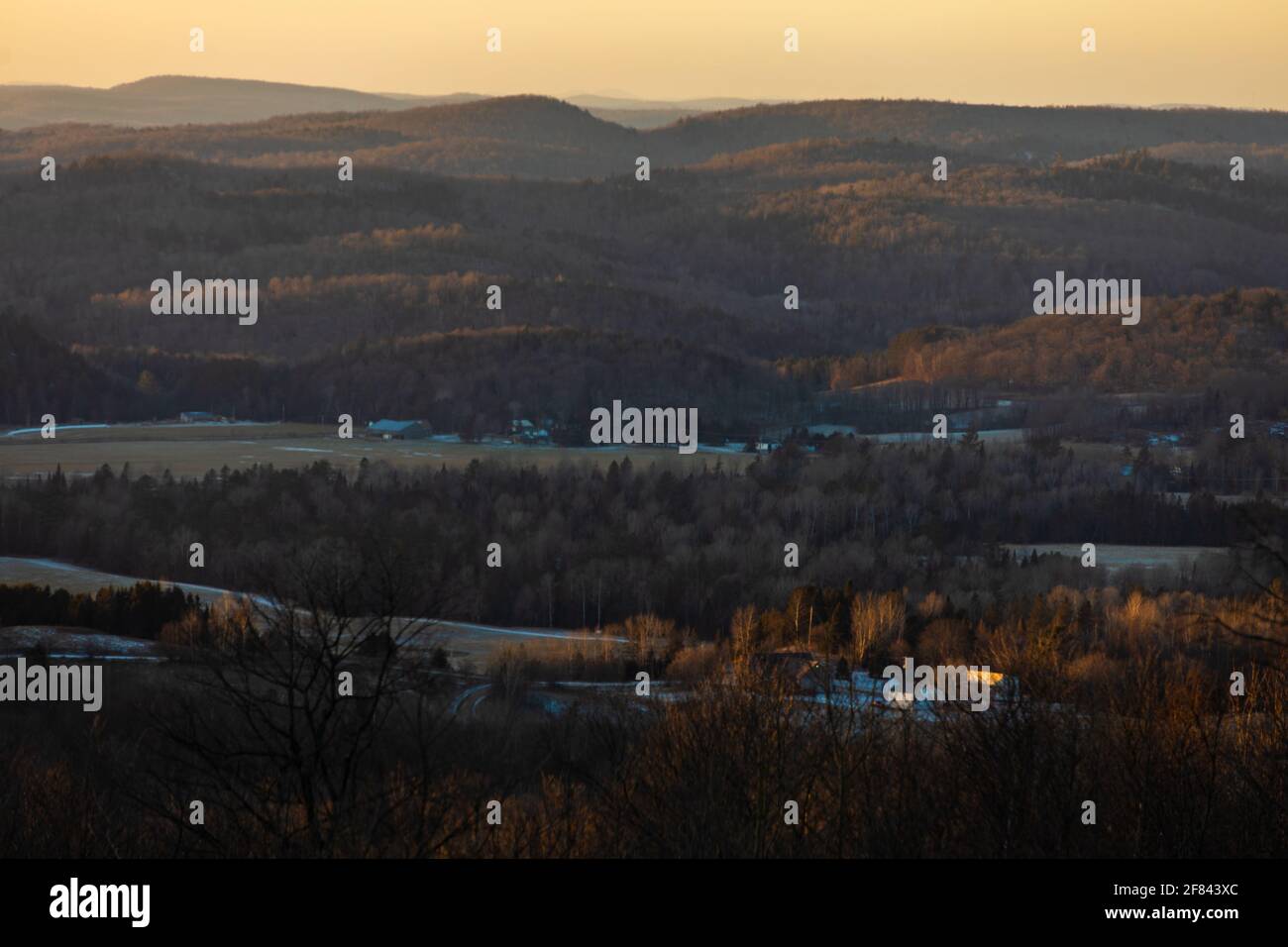 Blick auf ein Tal unten bei einem gelben Sonnenuntergang Stockfoto