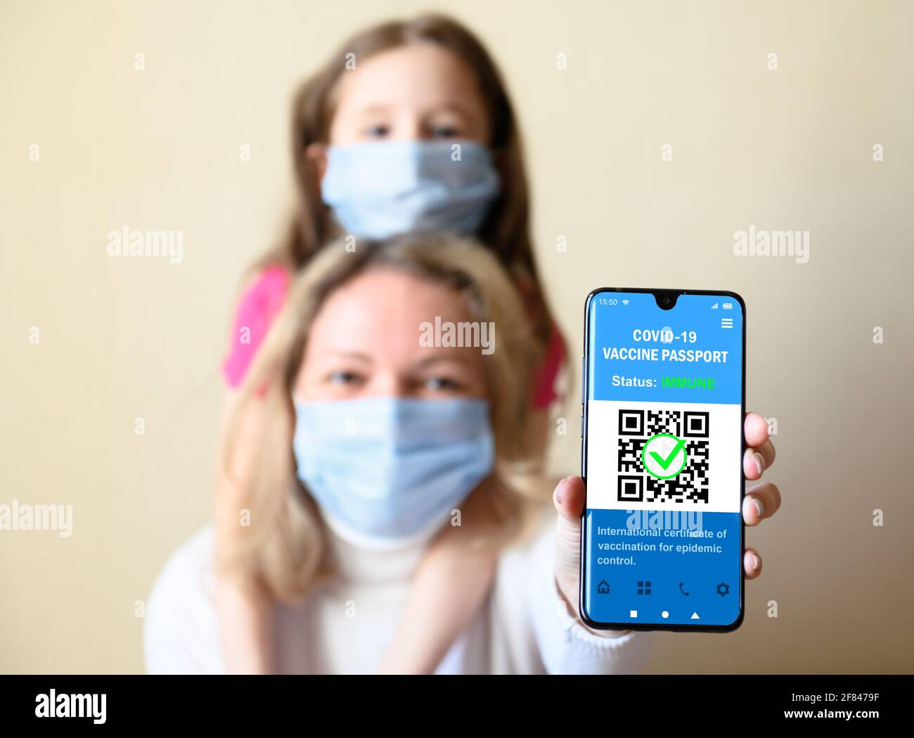 Gesundheitspass der COVID-19-Impfung im Mobiltelefon, glückliche Frau und Kind halten Smartphone mit Zertifikat-App der Immunisierung, digitales Coronavirus Stockfoto