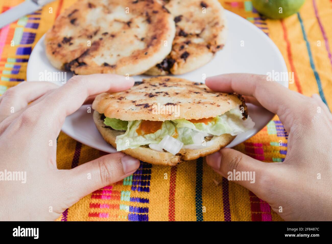Mexikanisches Essen gordita de Chicharron gefüllt mit Zwiebeln, Koriander, Salat, würziger chilisauce und Käse Stockfoto