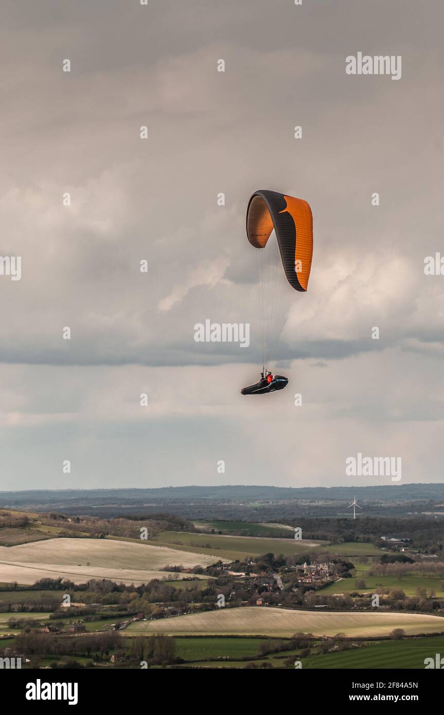 Firle, Lewes, East Sussex, Großbritannien. April 2021. Gleitschirmfliegen von den wunderschönen South Downs im kalten Nordwind wurde durch Squalls und gelegentliche Schneegüter unterbr... Es wird eine kalte Nacht mit der Möglichkeit von Schneeverwehungen morgen vorhergesagt. Kredit: David Burr/Alamy Live Nachrichten Stockfoto