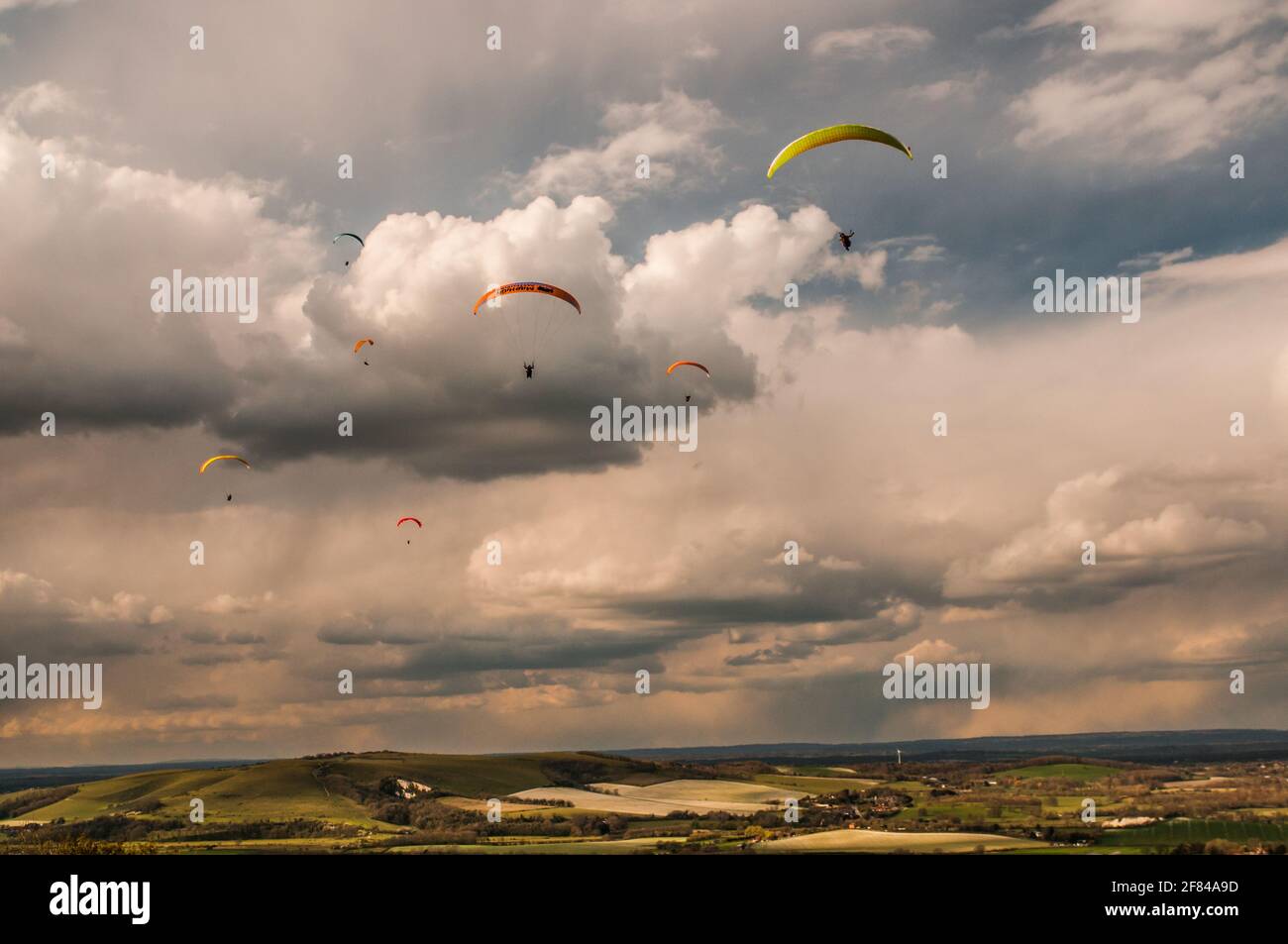 Firle, Lewes, East Sussex, Großbritannien. April 2021. Gleitschirmfliegen von den wunderschönen South Downs im kalten Nordwind wurde durch Squalls und gelegentliche Schneegüter unterbr... Es wird eine kalte Nacht mit der Möglichkeit von Schneeverwehungen morgen vorhergesagt. Kredit: David Burr/Alamy Live Nachrichten Stockfoto