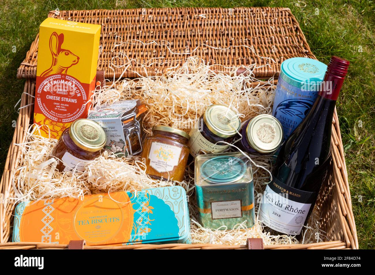 Fortnum & Mason Korb legte sich auf das Gras in Ein Garten in Cornwall Stockfoto