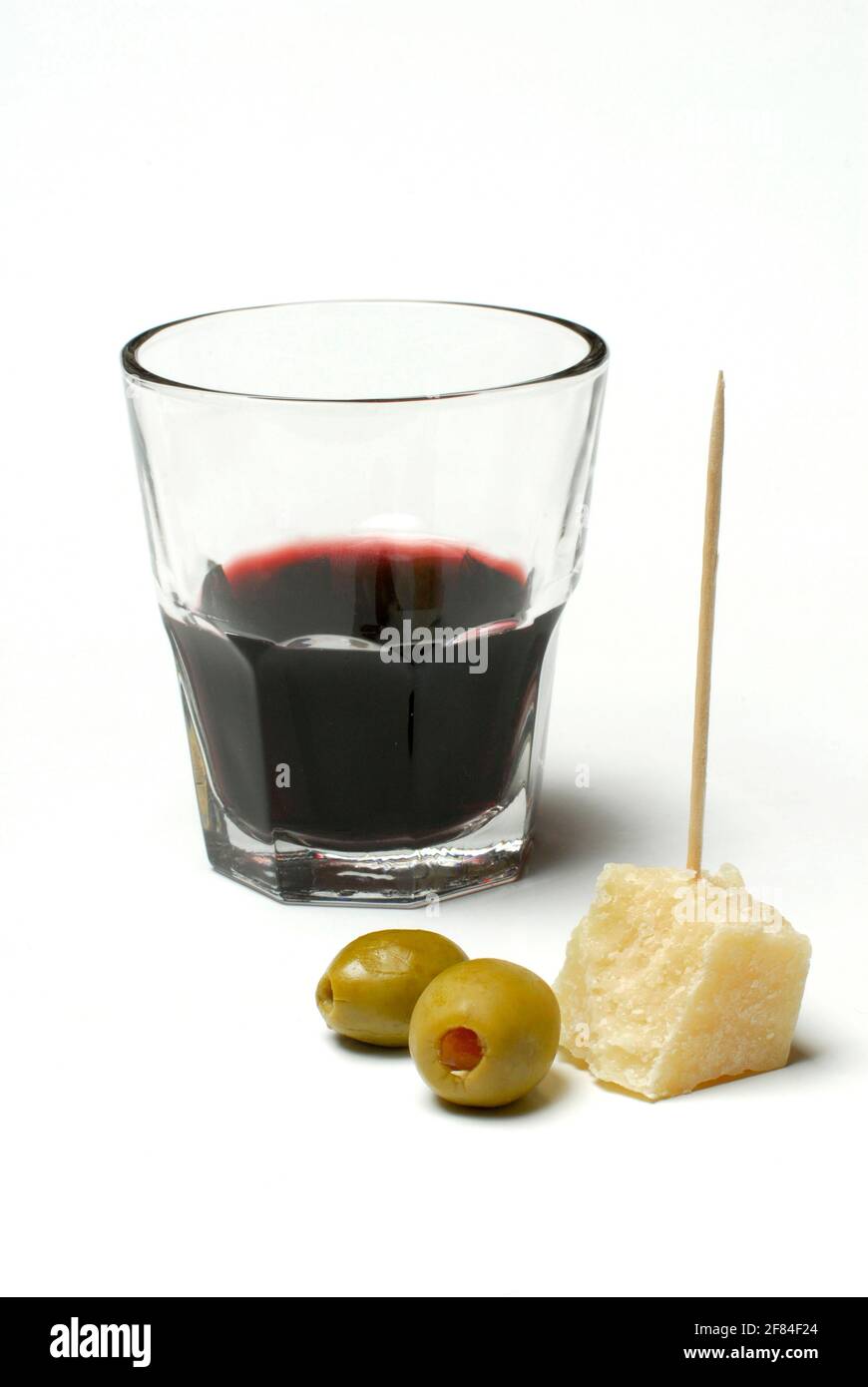 Parmesankäse, gefüllte Oliven und ein Glas Rotwein, Parmesan Stockfoto