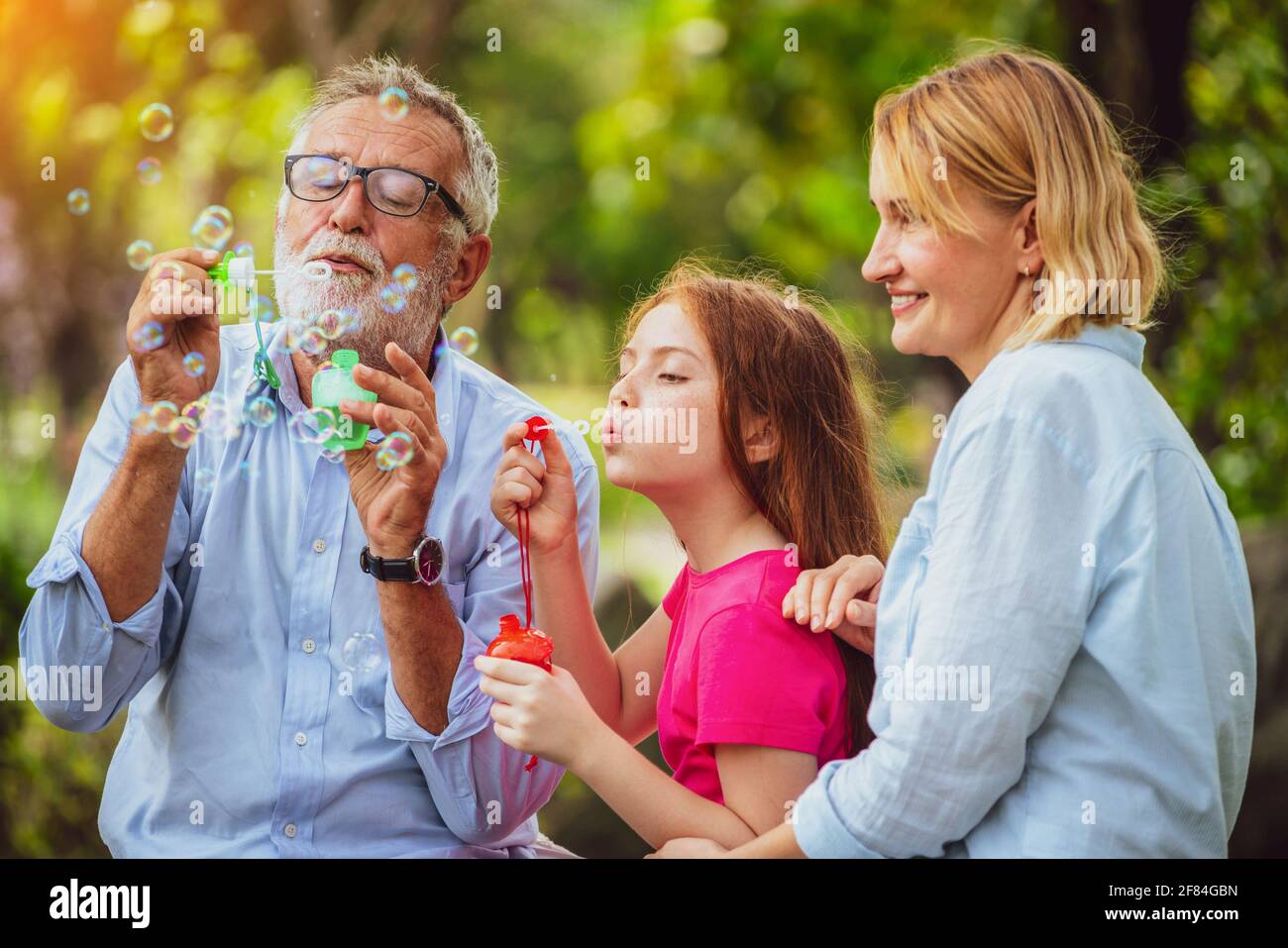 Happy Family bläst Seifenblasen zusammen beim Gehen, Urlaub am Wochenende in den Garten im Sommer. Kid Bildung und Aktivitäten für die ganze Familie. Stockfoto