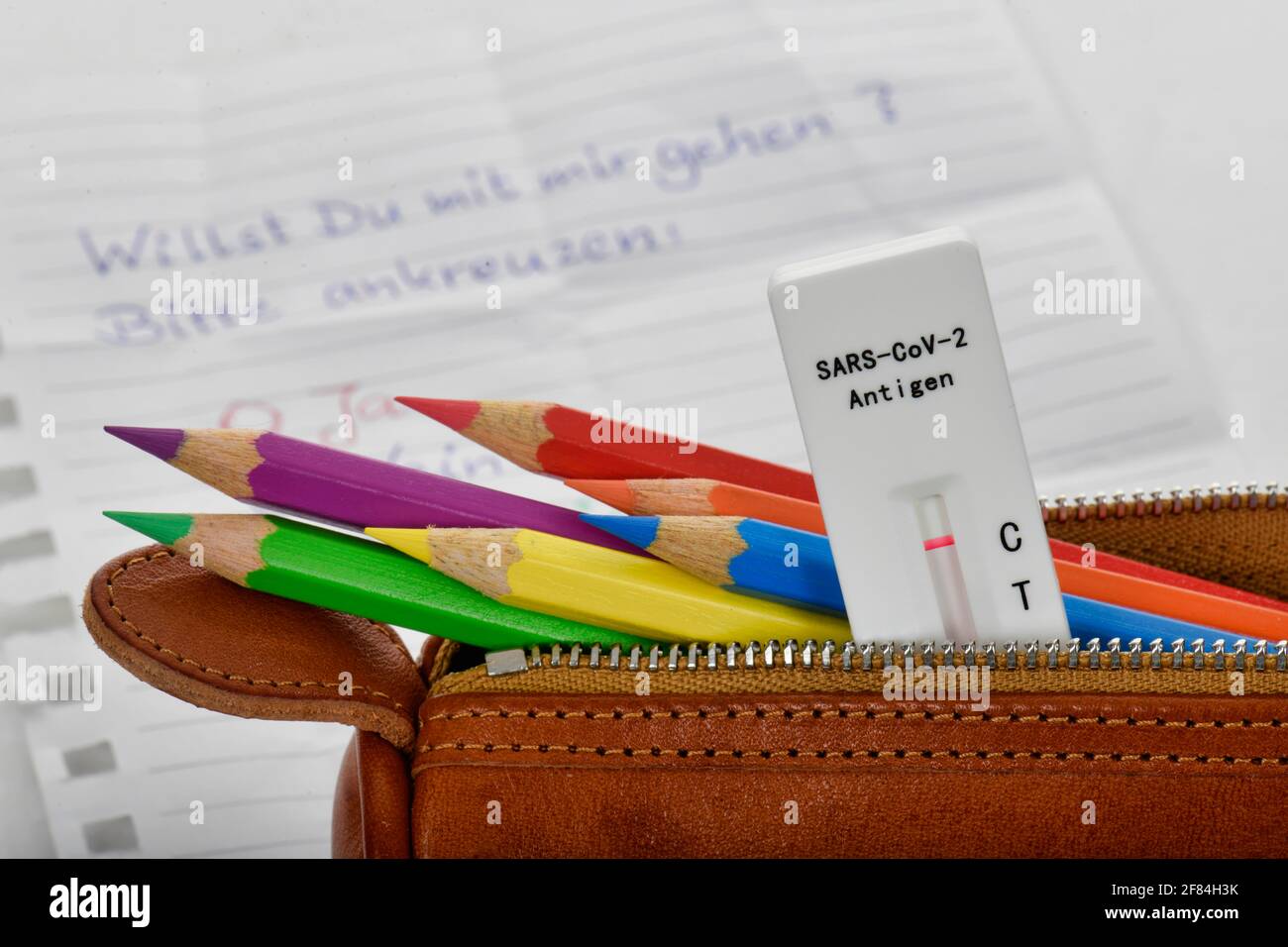 Symbolisches Bild obligatorische Tests an Schulen, schnelle Testkassette liegt in Bleistift-Etui, face-to-face-Unterricht, Corona-Krise, Deutschland Stockfoto
