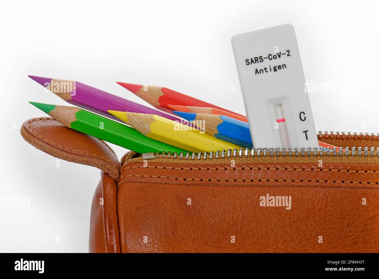 Symbolisches Bild obligatorische Tests an Schulen, schnelle Testkassette liegt in Bleistift-Etui, face-to-face-Unterricht, Corona-Krise, Deutschland Stockfoto