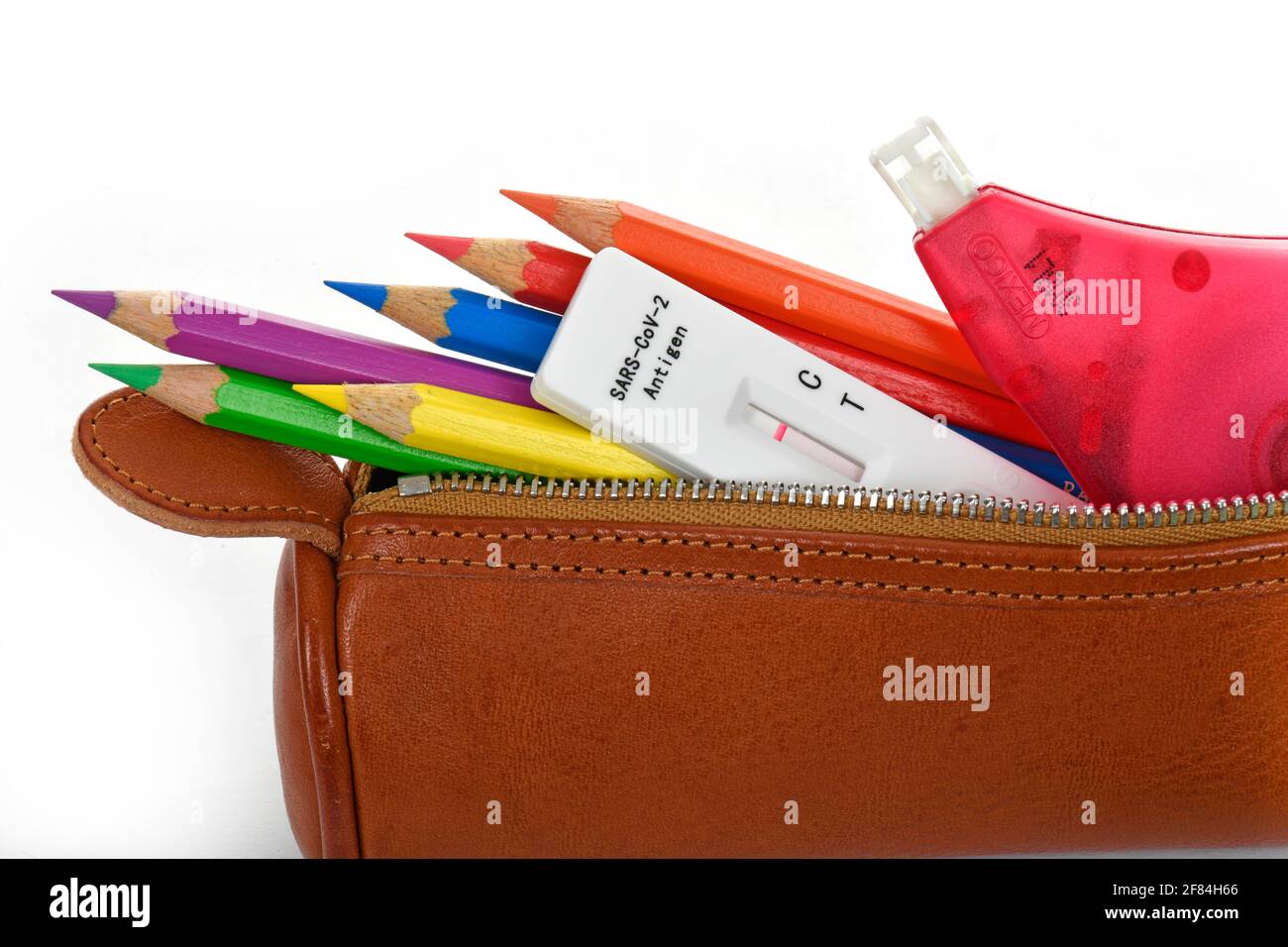 Symbolisches Bild obligatorische Tests an Schulen, schnelle Testkassette liegt in Bleistift-Etui, face-to-face-Unterricht, Corona-Krise, Deutschland Stockfoto