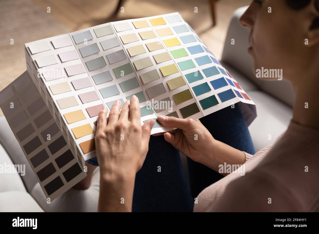 Junge Frau wählen Farbe der Wände in der Wohnung nach der Renovierung Stockfoto