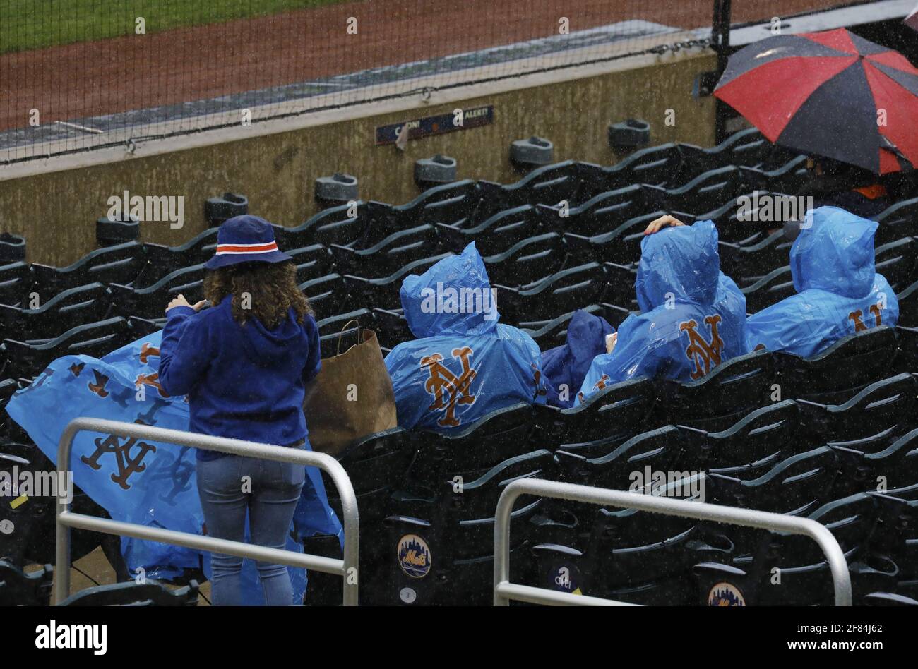 Queens, Usa. April 2021. Fans von New York Mets decken sich mit Plastik, als der Regen beim ersten Inning gegen die Miami Marlins am Sonntag, den 11. April 2021, im Citi Field in New York City fällt. Foto von Peter Foley/UPI Credit: UPI/Alamy Live News Stockfoto