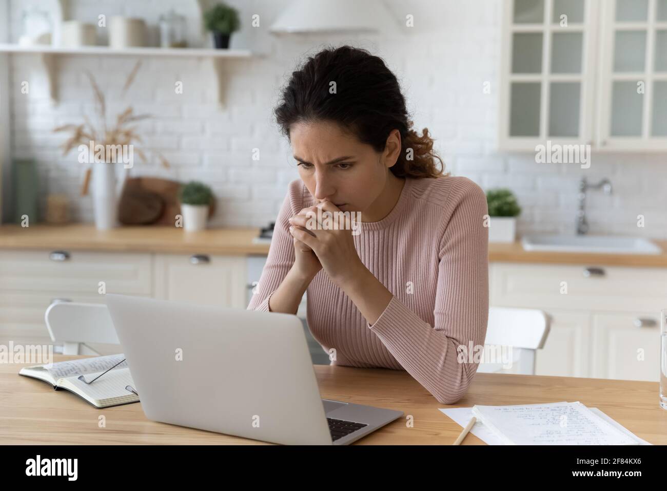 Ängstliche lateinische Frau sitzen am Küchenarbeitsplatz treffen schwierige Problem Stockfoto