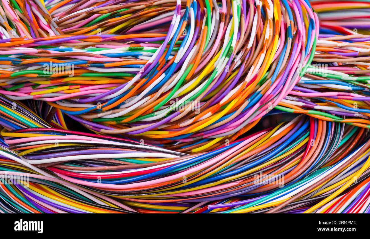 Bunte Hintergrund von mehradrigem Kabel Haufen. Nahaufnahme des Kabelgestänges. Schöne Zöpfe aus elektrischen Drähten in abstrakter Farbstruktur. Technik. Stockfoto