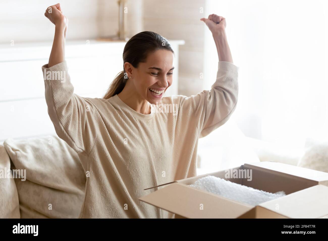 Überglücklich weibliche Käuferin begeistert mit Online-Bestellung Stockfoto
