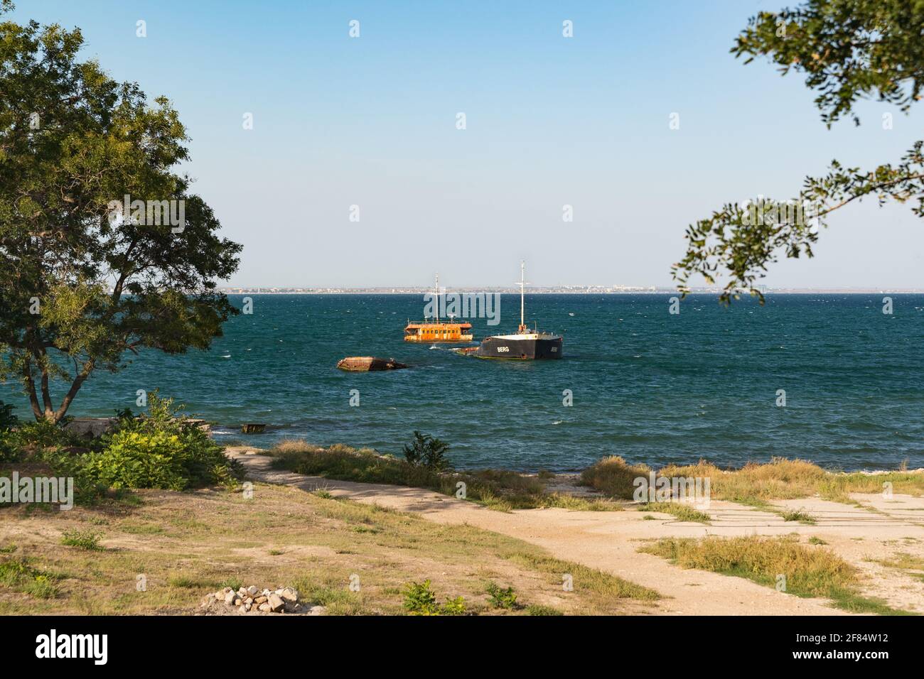 Russland, Krim, Feodosia - 18. September 2020. Der rostige Rumpf des lange versunkenen BERGSCHIFFS vor der Küste im Schwarzen Meer in der Nähe des Ferienortes Stockfoto