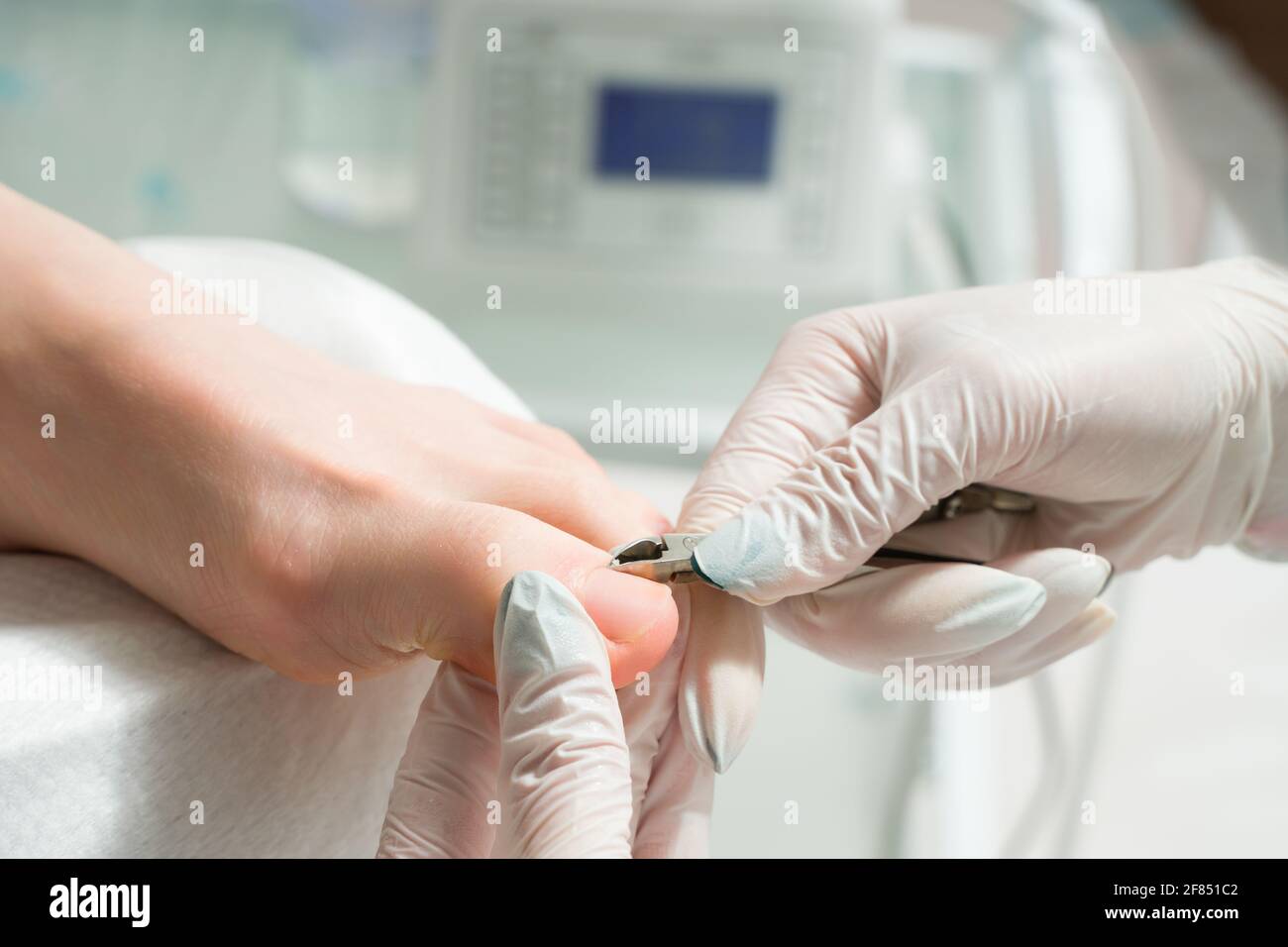 Ein podiatrischer Arzt, der sich um die Zehennägel einer Frau kümmert. Kosmetische Verfahren der Füße Stockfoto