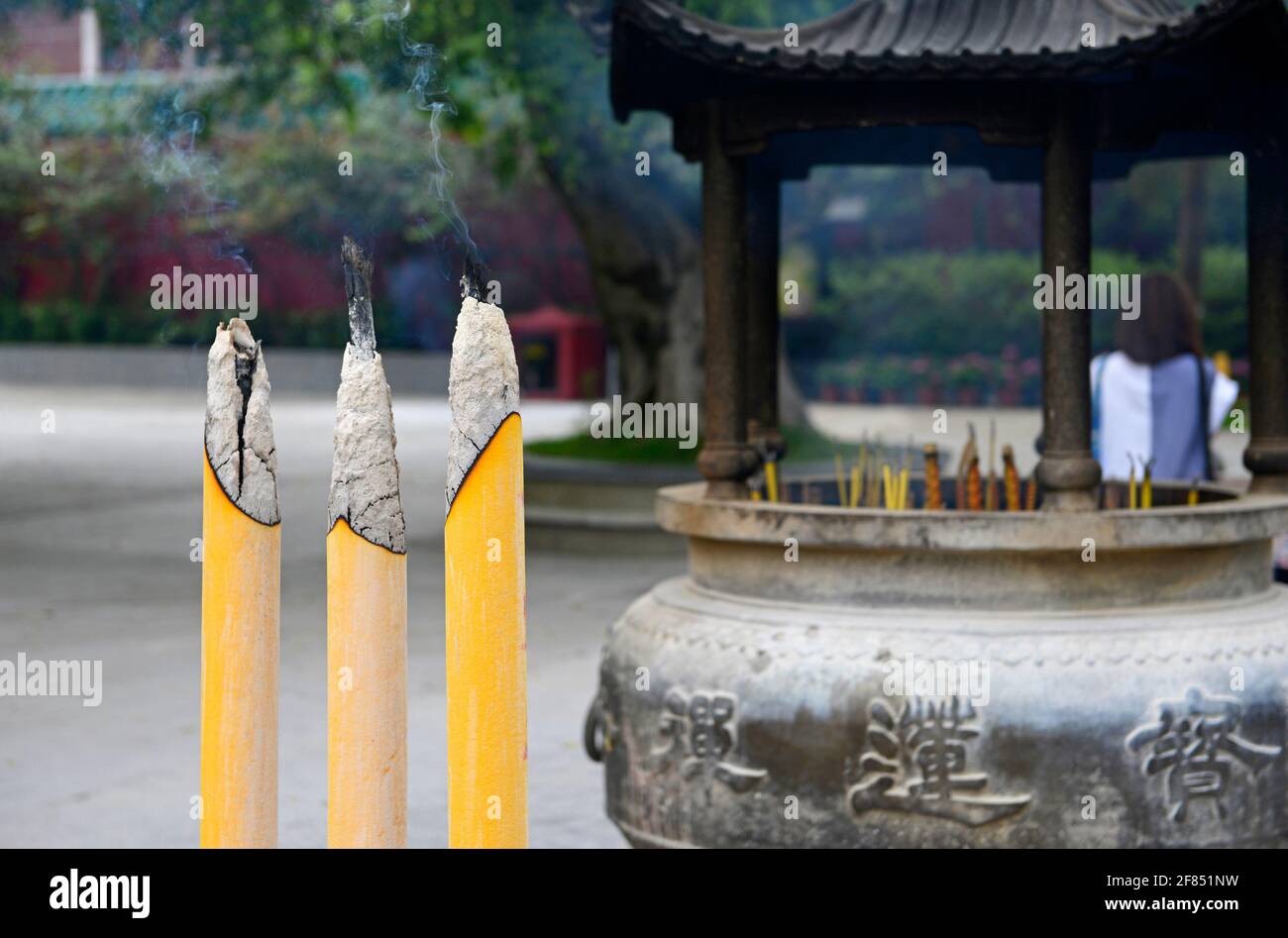 Drei große Räucherstäbchen brennen im buddhistischen Kloster Po Lin in Ngongping auf der Insel Lantau, Hongkong, China Stockfoto