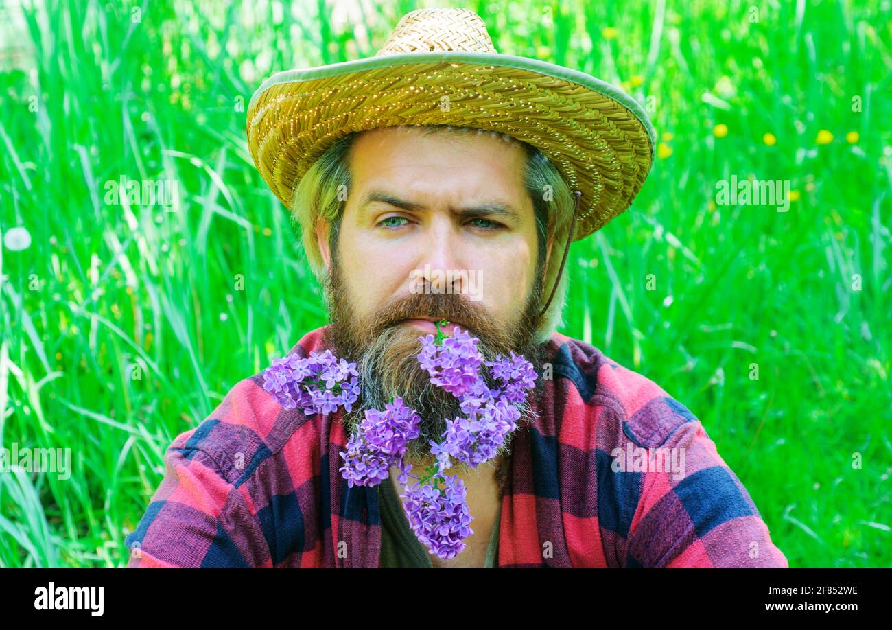 Schöner bärtiger Mann mit Blumen im Bart. Mann mit dekorierten Bart. Stockfoto