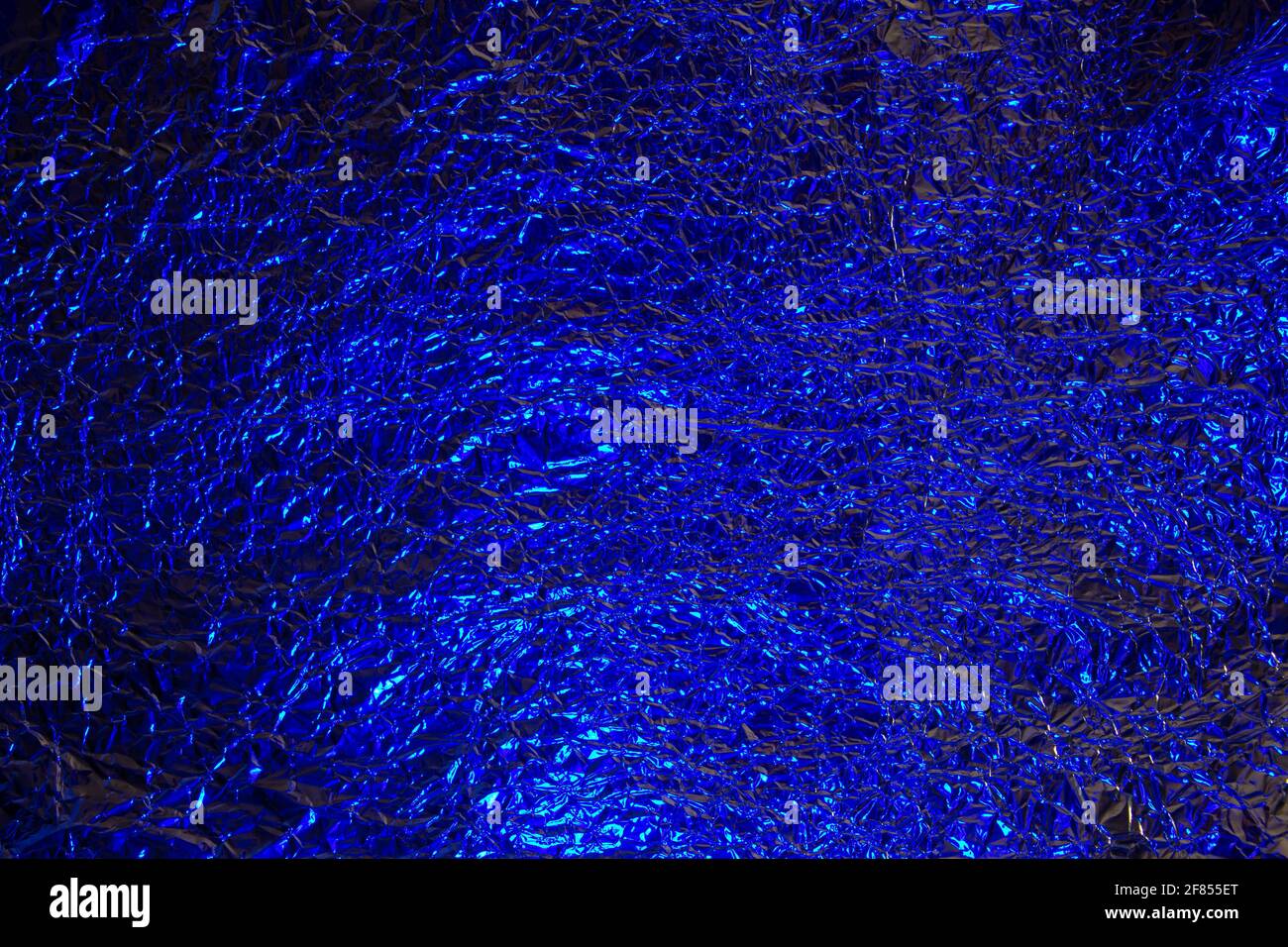 Abstrakte blaue Aluminium zerknittert Folie Hintergrund Textur reflektiert blaues Licht Stockfoto