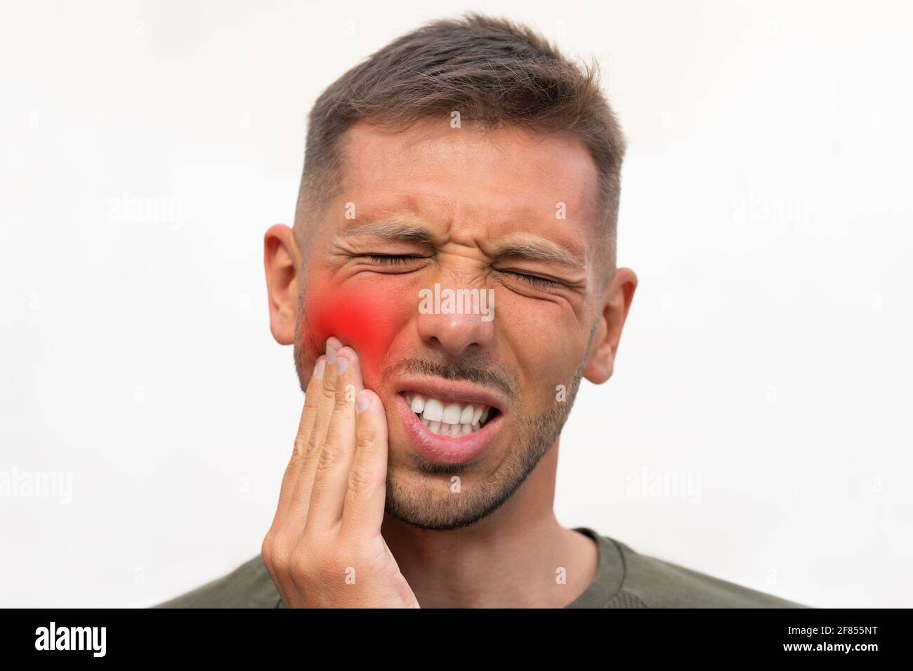 Mann, der seine Wange wegen starker Zahnschmerzen mit rot hervorgehobenen Bereich berührt. Mann, der an Zahnschmerzen leidet. Zahnproblem. Mann, der Zahnschmerzen spürt Stockfoto