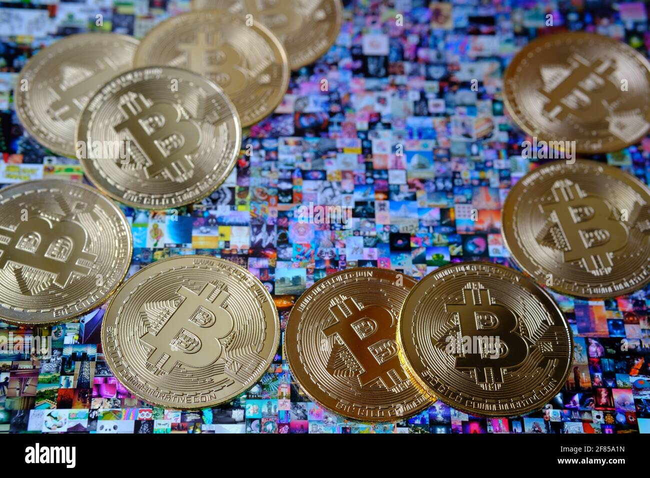 Bitcoin-Münzen, die mit Beeple ' EVERYDAYS: THE FIRST 5000 DAYS' Collagekunst auf dem ipad platziert wurden, signiert mit NFT Token. Selektiver Fokus. Konzept. Stafford, Großbritannien, Stockfoto