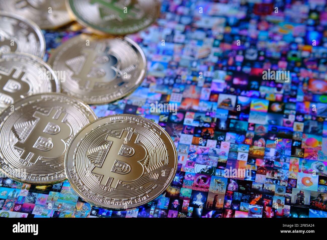 Bitcoin-Münzen, die mit Beeple ' EVERYDAYS: THE FIRST 5000 DAYS' Collagekunst auf dem ipad platziert wurden, signiert mit NFT Token. Selektiver Fokus. Konzept. Stafford, Großbritannien, Stockfoto
