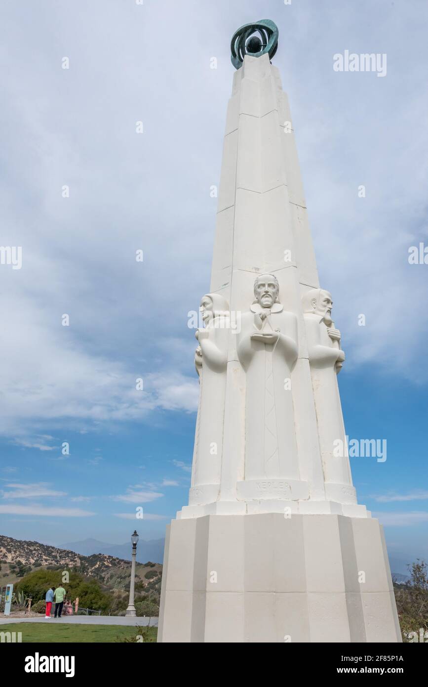 Nahaufnahme des modernen Obelisken des Griffith Observatoriums im Vordergrund mit Touristen, die einen wunderschönen Tag am Wahrzeichen von Los Angeles genießen. Stockfoto