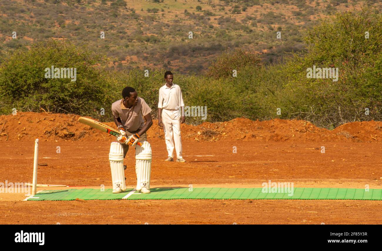 Mann bis zu schlagen in Cricket-Spiel in Kenia auf Ein Feldfeld in der Nähe von Dol Dol Stockfoto