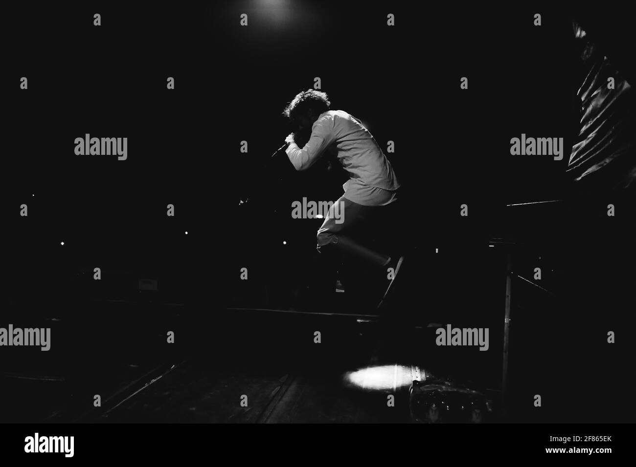 Mann springt auf der Bühne schwarz und weiß Stockfoto