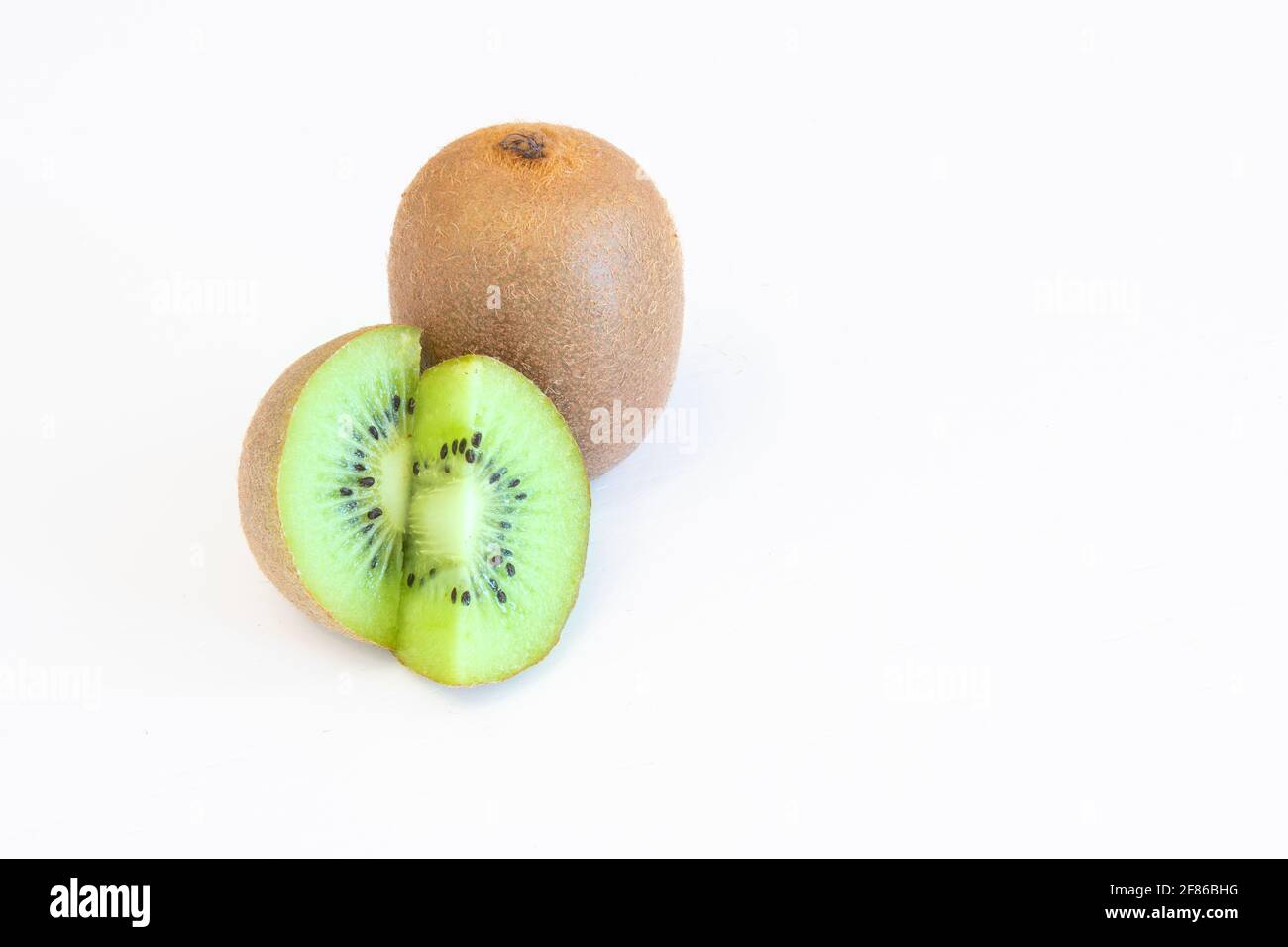 Ganze und halbiert Kiwi Früchte isoliert auf weißem Hintergrund mit Textbereich Stockfoto