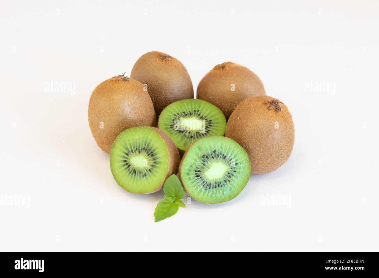 Ganze und halbiert Kiwi Früchte isoliert auf weißem Hintergrund mit Textbereich Stockfoto