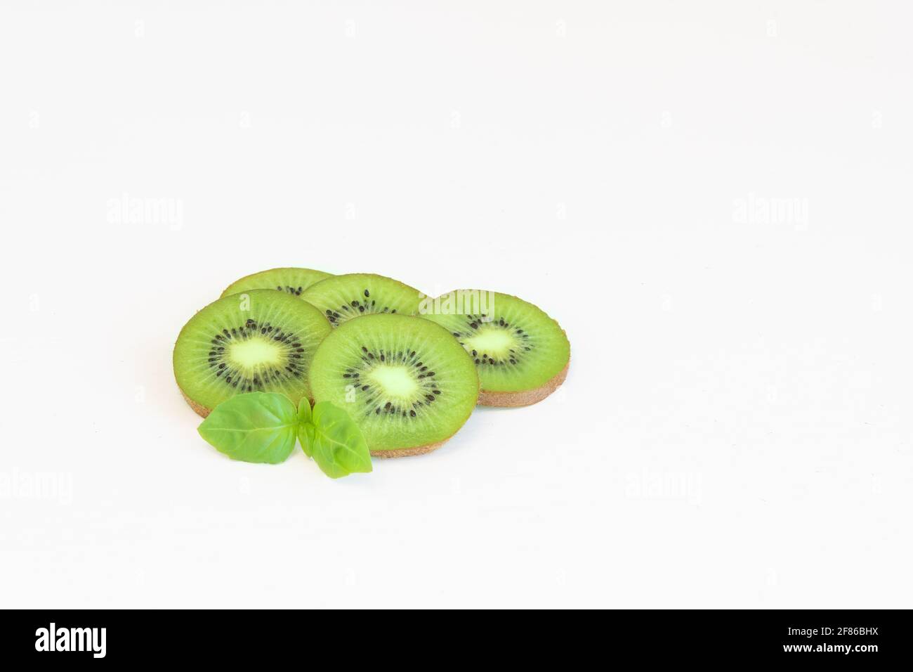 Nahaufnahme frischer Kiwi-Scheiben mit Blatt auf Weiß isoliert Hintergrund Stockfoto