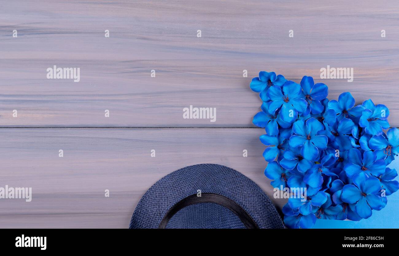 Vatertag Grußkarte Konzept, kopieren Platz für Text auf einem hölzernen Hintergrund mit blauen Blumen und Hut Stockfoto