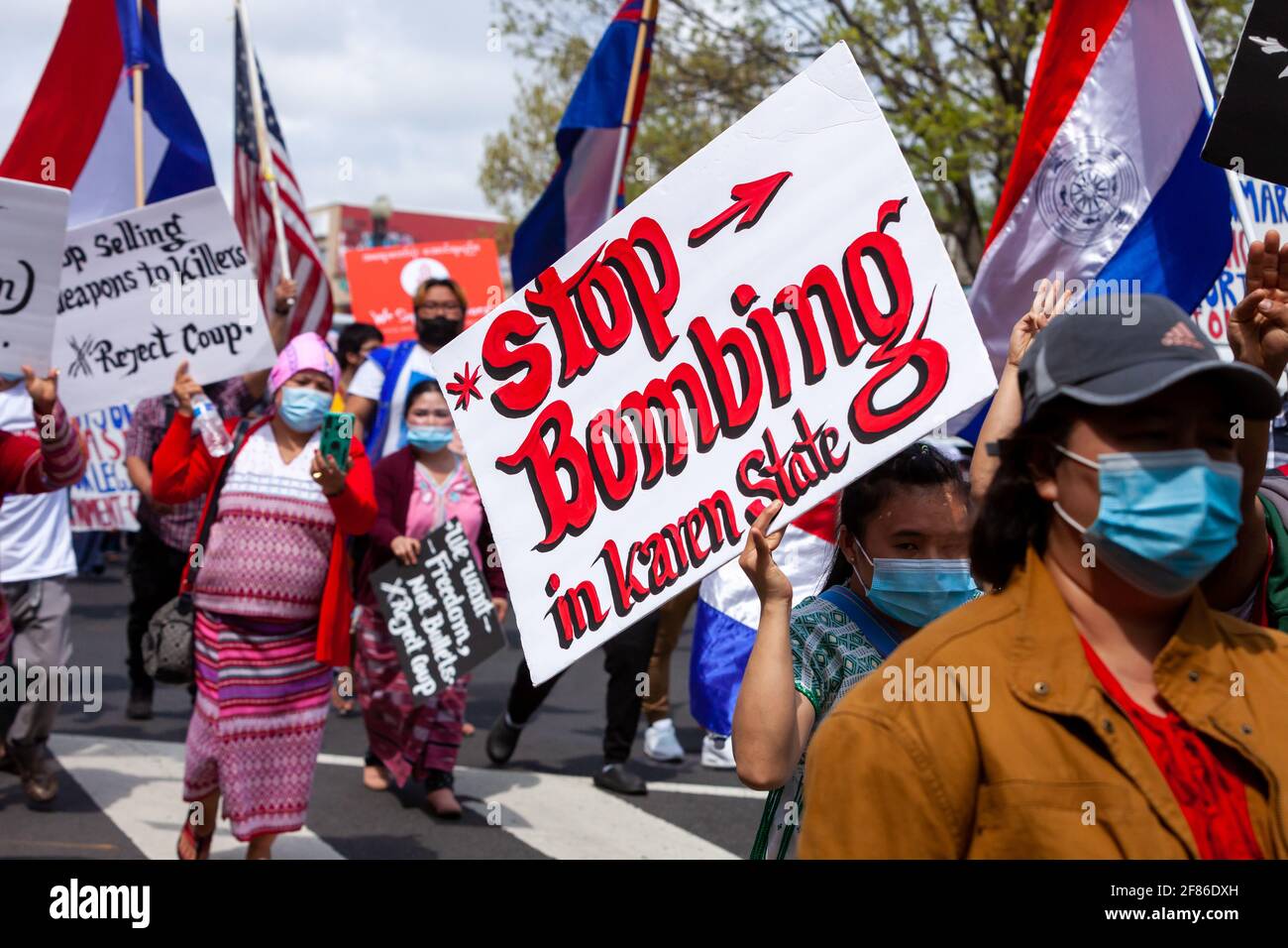 Ein Protestler, der gegen den Militärputsch in Myanmar marschiert, trägt ein Zeichen, das auch ein Ende der Gewalt im Staat Karen fordert, in Bezug auf den LON Stockfoto