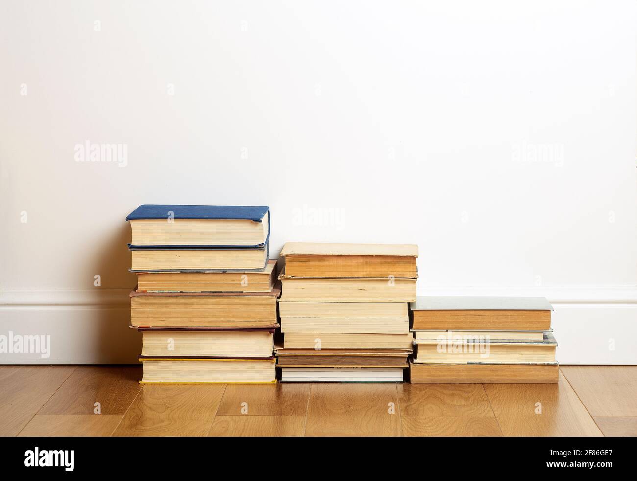 Home Education Konzept. Bücher auf dem Hintergrund einer weißen Wand in einem leeren Raum. Lesen und studieren. Hochwertige Fotos Stockfoto