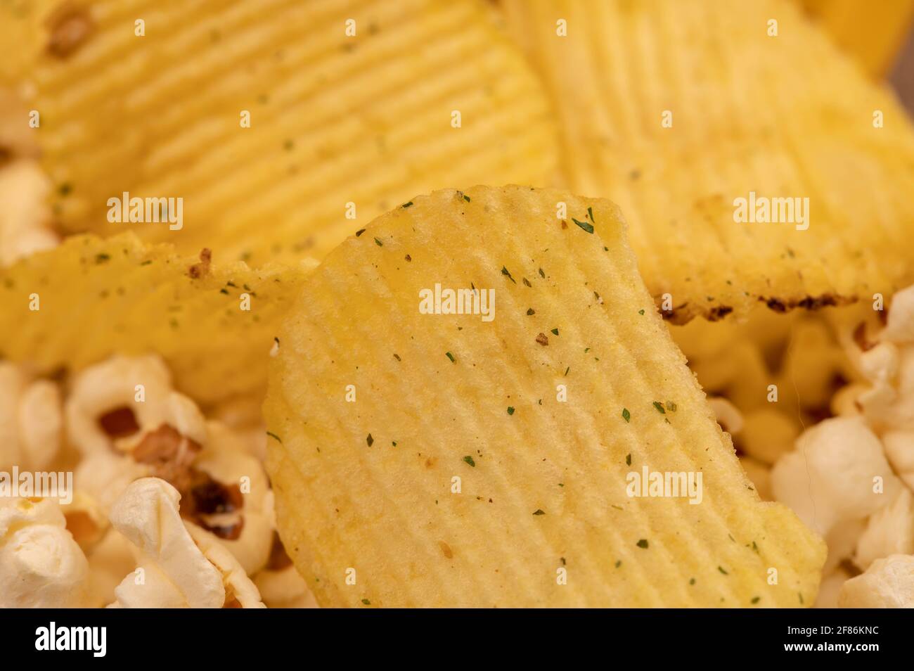 Popcorn auf dem Tisch verstreut und Kartoffelchips. Selbstisolierung bei der Covid-19-Pandemie. Nahaufnahme mit selektivem Fokus. Stockfoto