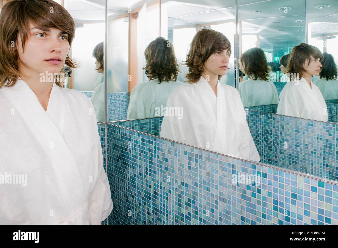 Reflexion der jungen Frau im Badezimmerspiegel Stockfoto