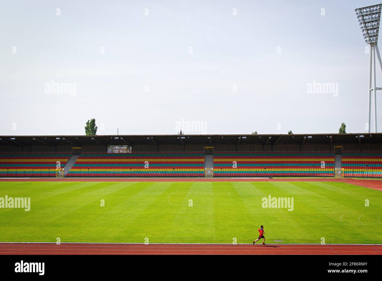Mann läuft auf der Strecke im sonnigen Fußballstadion Stockfoto