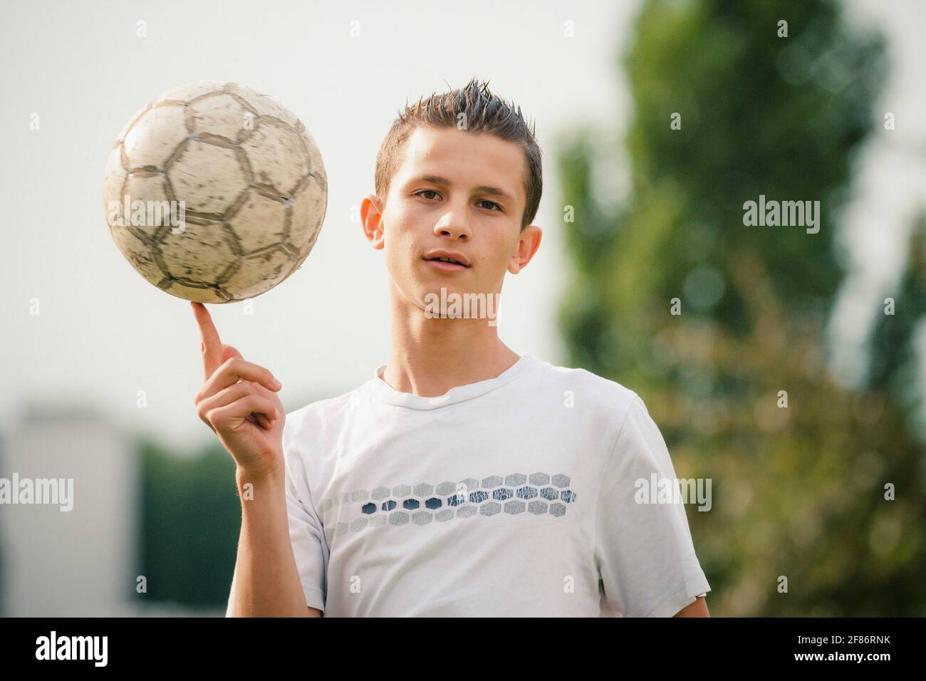 Portrait cool Teenager Jungen Spinnen Fußball auf dem Finger Stockfoto